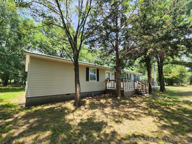 view of home's exterior with a deck and a lawn