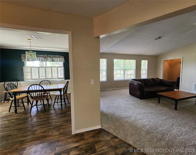 living room with an inviting chandelier, dark hardwood / wood-style flooring, and vaulted ceiling