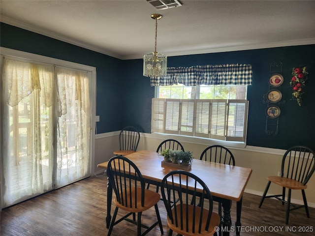 dining area featuring ornamental molding, a chandelier, and dark hardwood / wood-style flooring