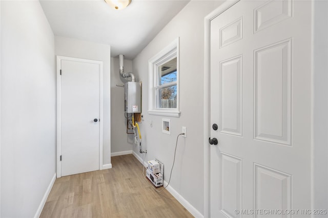 laundry area with water heater, washer hookup, and light hardwood / wood-style flooring