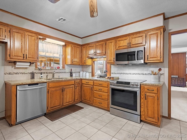 kitchen with sink, appliances with stainless steel finishes, ornamental molding, a textured ceiling, and decorative backsplash