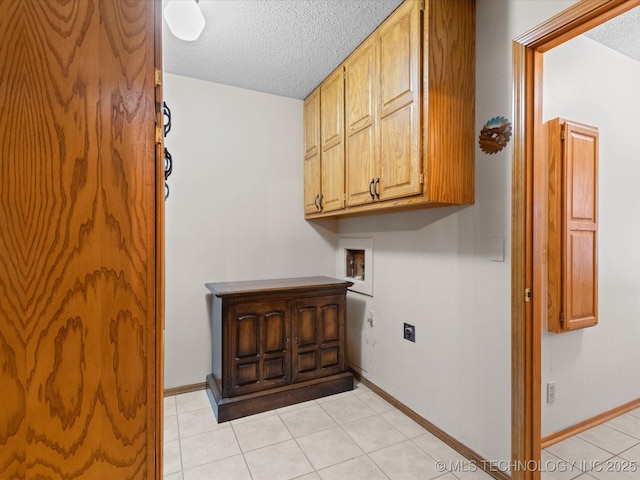 washroom with light tile patterned floors, hookup for a washing machine, cabinets, a textured ceiling, and hookup for an electric dryer