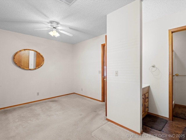 carpeted spare room with ceiling fan and a textured ceiling