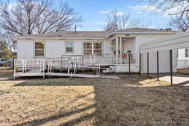 back of property with a garage and a lawn