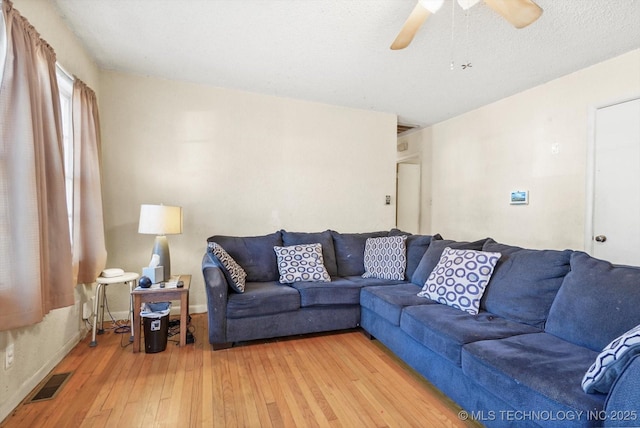 living room featuring hardwood / wood-style floors, a textured ceiling, and ceiling fan