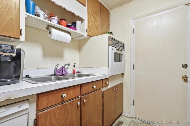 kitchen featuring white appliances and sink