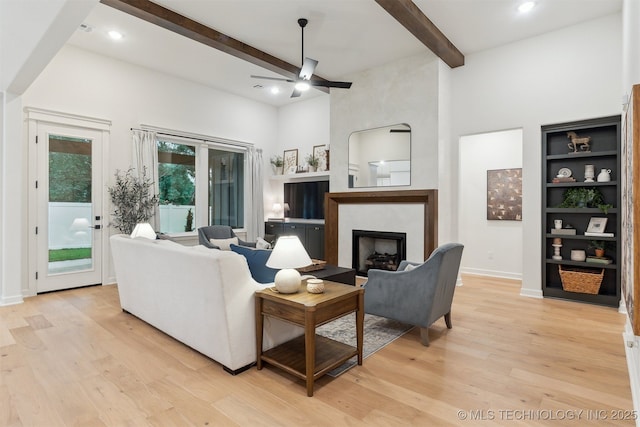 2325 E 134th Cir, Bixby, OK 74008 - living area featuring ceiling fan, beam ceiling, light wood finished floors, a high ceiling, and a fireplace