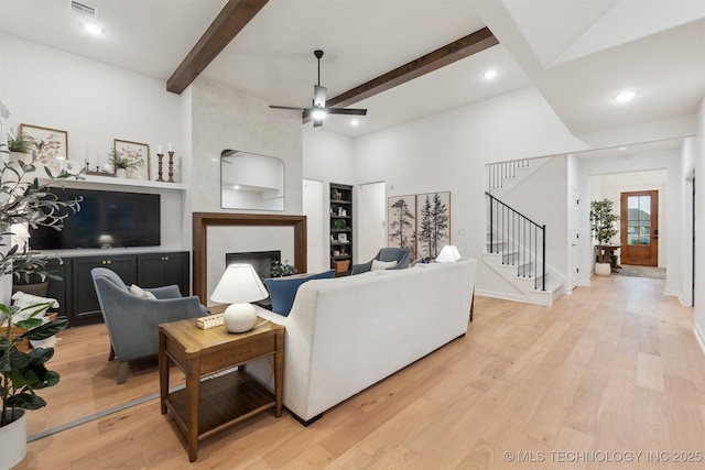 2325 E 134th Cir, Bixby, OK 74008 - living area with a large fireplace, beamed ceiling, stairway, ceiling fan, and light wood finished floors