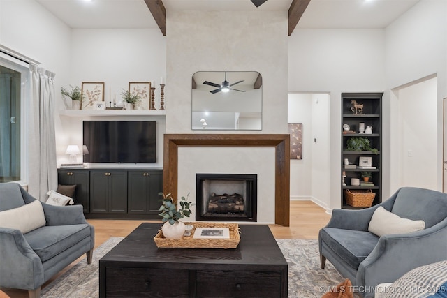 2325 E 134th Cir, Bixby, OK 74008 - living room with beam ceiling, light wood-type flooring, ceiling fan, built in features, and a fireplace