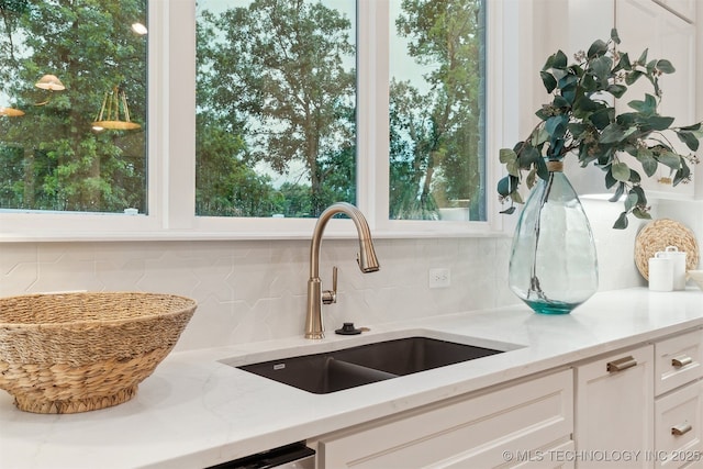 2325 E 134th Cir, Bixby, OK 74008 - kitchen with tasteful backsplash, white cabinetry, and light stone countertops