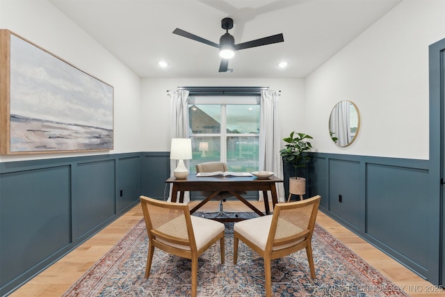 2325 E 134th Cir, Bixby, OK 74008 - dining room featuring light wood-style flooring, a ceiling fan, a decorative wall, a desk, and a wainscoted wall