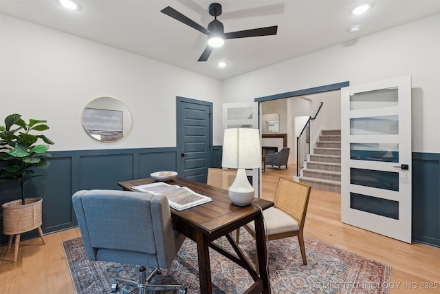 2325 E 134th Cir, Bixby, OK 74008 - home office featuring ceiling fan, a wainscoted wall, light wood-style flooring, and a decorative wall