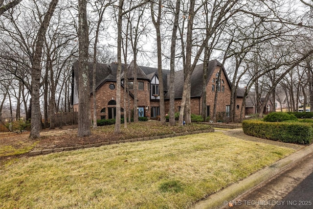 tudor-style house featuring a front yard