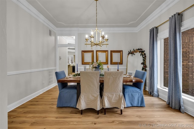 dining space featuring ornamental molding, a chandelier, light hardwood / wood-style flooring, and plenty of natural light