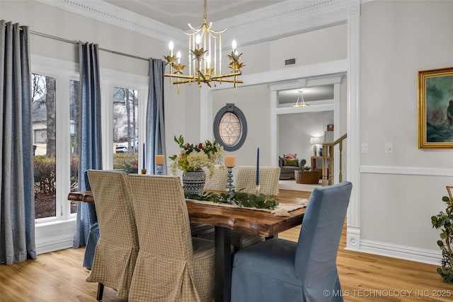 dining area featuring ornamental molding, a notable chandelier, and light hardwood / wood-style flooring