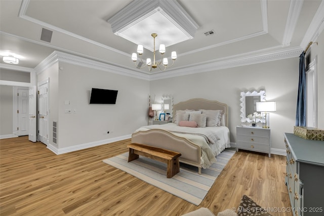 bedroom featuring ornamental molding, light hardwood / wood-style floors, a raised ceiling, and a chandelier