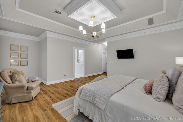 bedroom featuring hardwood / wood-style flooring, a raised ceiling, crown molding, and an inviting chandelier