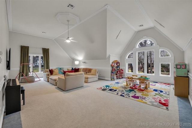 carpeted living room featuring crown molding, ceiling fan, and vaulted ceiling