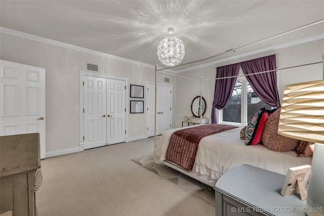 carpeted bedroom featuring ornamental molding, a chandelier, and two closets