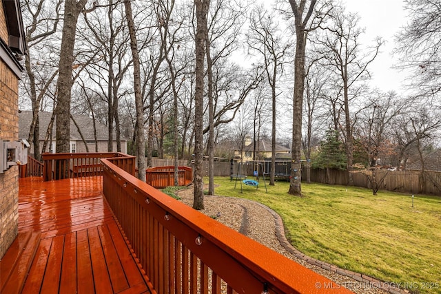 deck featuring a trampoline and a yard