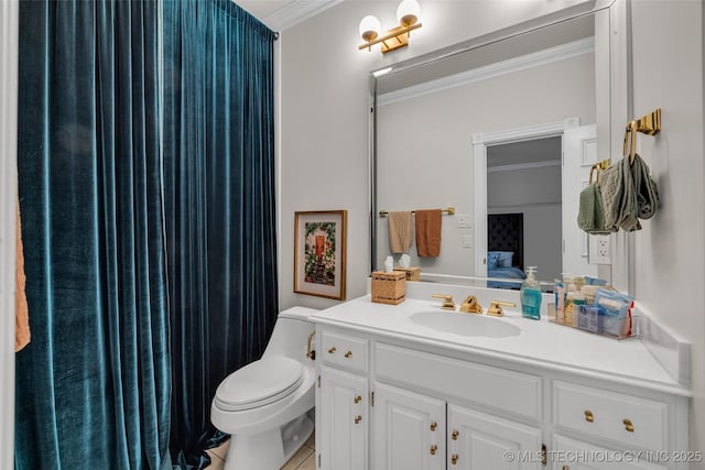 bathroom with ornamental molding, toilet, and vanity