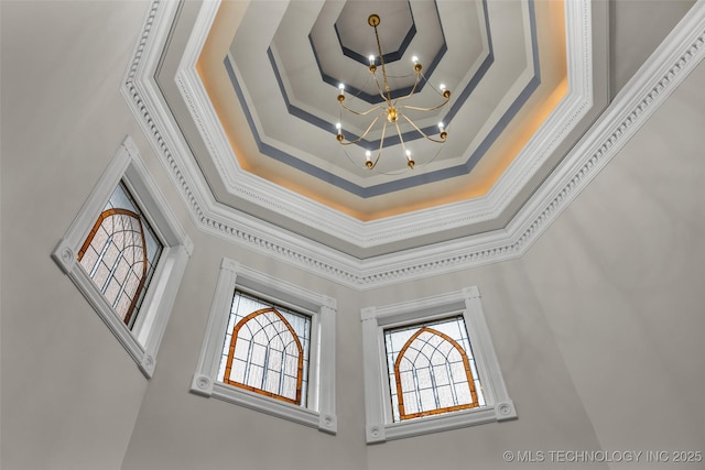 room details with an inviting chandelier, crown molding, and a raised ceiling