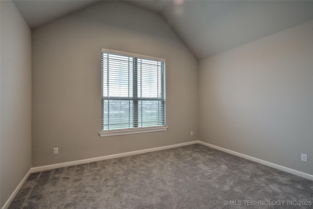 carpeted empty room featuring vaulted ceiling