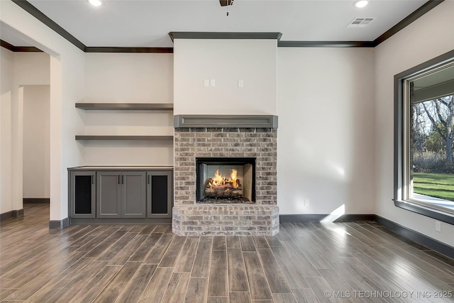 unfurnished living room featuring crown molding, a fireplace, and dark hardwood / wood-style floors