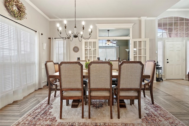 dining space with light parquet floors, ornamental molding, and ceiling fan with notable chandelier