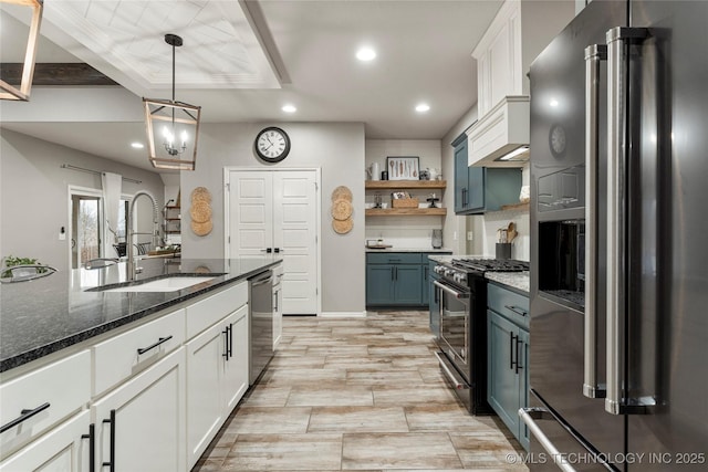 kitchen featuring white cabinetry, sink, decorative light fixtures, and high quality appliances