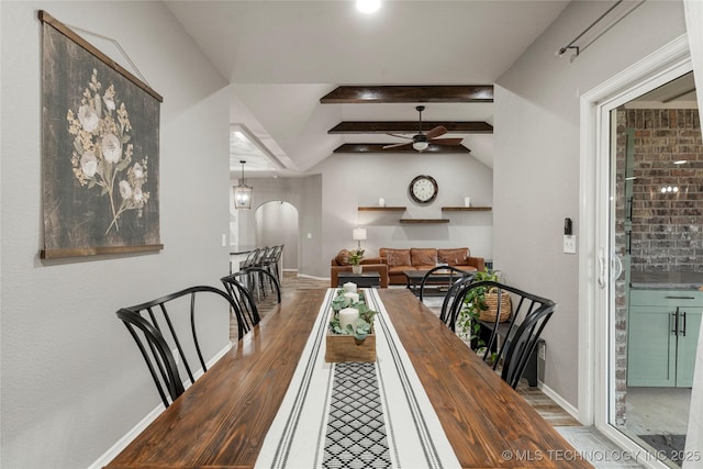 dining area featuring ceiling fan, wood-type flooring, and lofted ceiling with beams