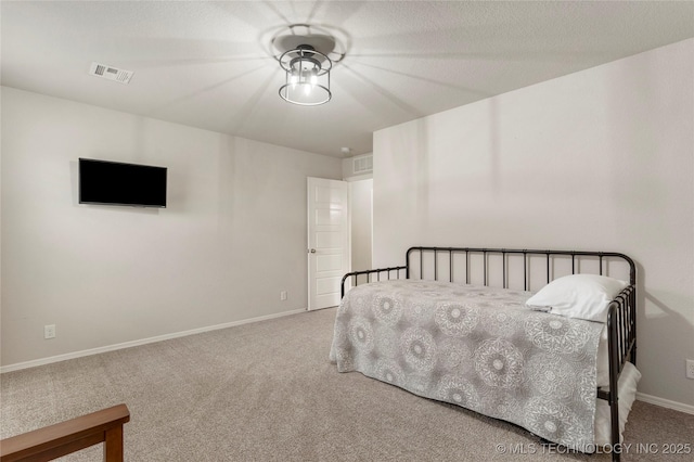 bedroom with light carpet and a textured ceiling