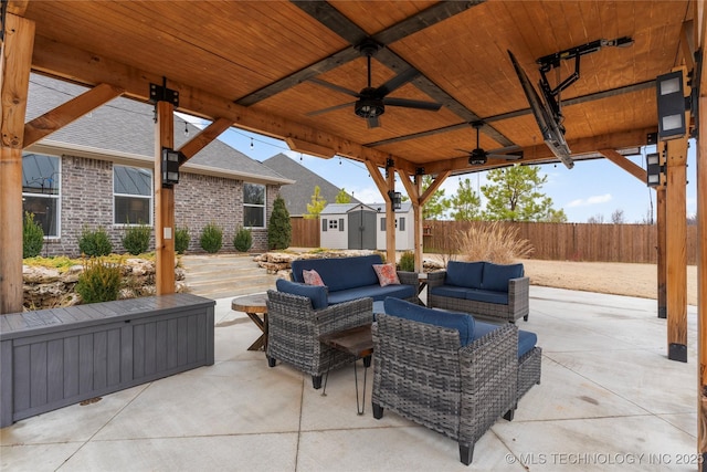 view of patio / terrace featuring a storage shed, an outdoor living space, and ceiling fan