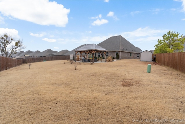 back of property with a gazebo and a shed