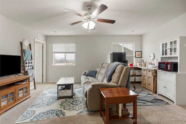 living room with light carpet, a wealth of natural light, and ceiling fan