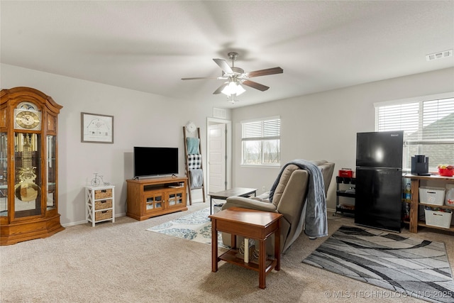 carpeted living room featuring ceiling fan