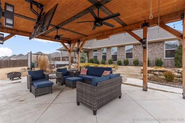 view of patio / terrace featuring ceiling fan and an outdoor living space with a fire pit