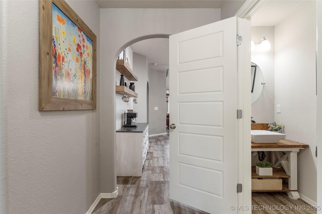 hallway featuring sink and light hardwood / wood-style flooring