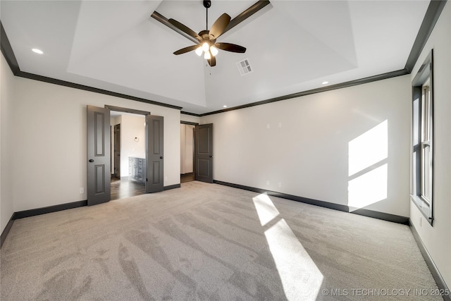 unfurnished bedroom with ceiling fan, a towering ceiling, connected bathroom, ornamental molding, and light colored carpet