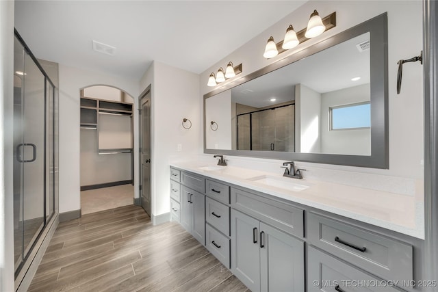 bathroom featuring vanity, hardwood / wood-style flooring, and a shower with shower door