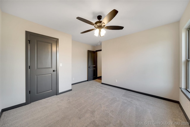 unfurnished bedroom featuring light carpet and ceiling fan