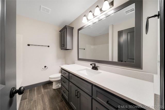 bathroom with vanity, a shower, and toilet