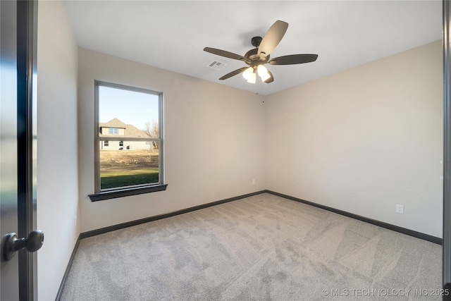 spare room featuring light colored carpet and ceiling fan