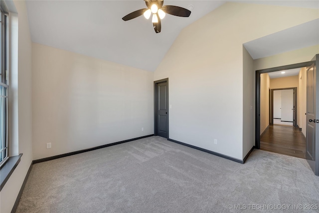 spare room featuring ceiling fan, high vaulted ceiling, and light carpet