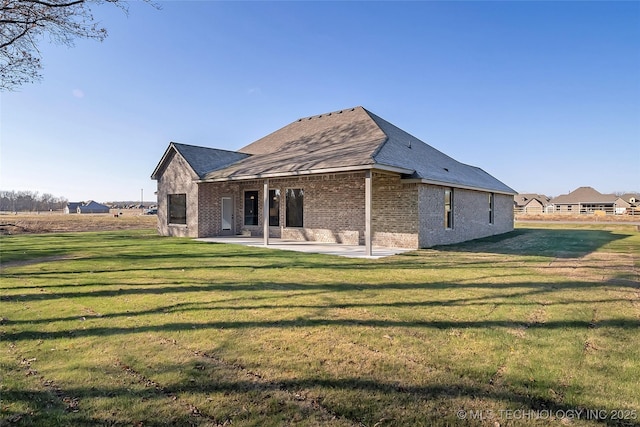 back of house with a lawn and a patio