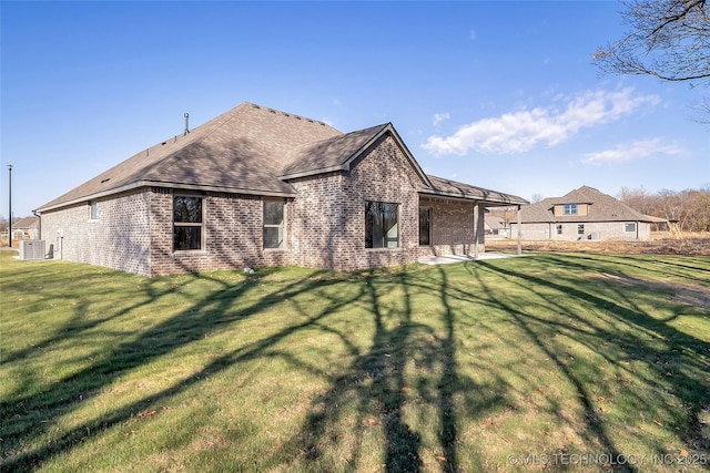 rear view of property featuring a patio and a lawn