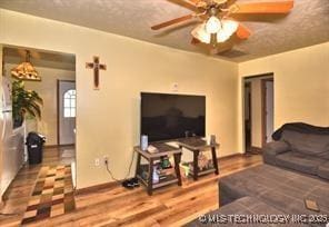 living room featuring a barn door, hardwood / wood-style floors, and ceiling fan