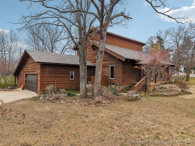 view of side of property featuring a yard and a garage