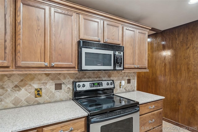 kitchen featuring light stone counters, appliances with stainless steel finishes, and tasteful backsplash