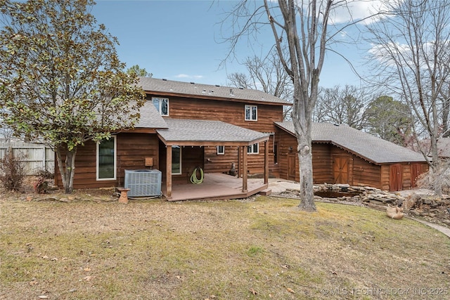 rear view of house with a wooden deck, a yard, and central AC